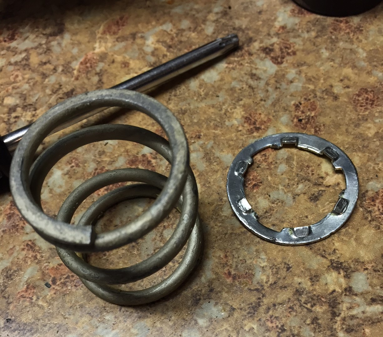 Broken plastic spur gear spring and worm gear removed from a mirror housing